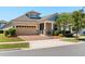 Charming single-story home featuring a brick driveway, two-car garage, and well-manicured landscaping at 2890 Avian Loop, Kissimmee, FL 34741