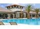A luxurious community pool with a clubhouse, lush landscaping, and comfortable lounge chairs for relaxation at 2890 Avian Loop, Kissimmee, FL 34741