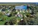 Aerial view of home near a lake, featuring a pool and spacious green yard surrounded by mature trees at 290 Orange Ave, St Cloud, FL 34769