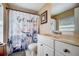 Charming bathroom with a unique shower curtain, vanity with storage, and neutral color scheme at 290 Orange Ave, St Cloud, FL 34769