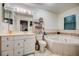 Bright bathroom with a soaking tub, white cabinets, and a mirrored vanity at 290 Orange Ave, St Cloud, FL 34769