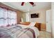 Cozy bedroom featuring tile floors, ceiling fan, and mounted flat screen TV at 290 Orange Ave, St Cloud, FL 34769