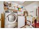 Efficient laundry room with a washer, dryer, sink, and storage shelves at 290 Orange Ave, St Cloud, FL 34769
