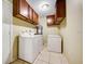 Functional laundry room with washer, dryer, and tile flooring for easy cleaning at 290 Orange Ave, St Cloud, FL 34769