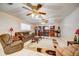 Cozy living room featuring comfortable seating, ceiling fans, and a fireplace with built-in shelving at 290 Orange Ave, St Cloud, FL 34769