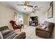 A comfortable living room with two ceiling fans, neutral paint, tile flooring, and seating at 290 Orange Ave, St Cloud, FL 34769