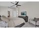 Bright bedroom with a ceiling fan, neutral decor, and a TV hanging above a modern chest of drawers at 3012 Samosa Hill Cir, Clermont, FL 34714