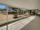 View from inside the screened lanai with white frame overlooking the backyard covered in mature trees and some shrubs at 38 Emerald Ct, Ocala, FL 34472