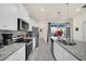 Kitchen features stainless appliances, granite countertops and a view to outdoor pool area at 3811 Lana Ave, Davenport, FL 33897
