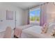 Bedroom features a patterned throw blanket on the bed, window with colorful curtains at 3862 Royal Azalea Way, Sanford, FL 32773