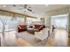 Spacious living room with wood floors, large windows, neutral décor, and comfortable seating arrangements at 3995 Sw 57Th Ct, Ocala, FL 34474