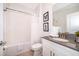 Bright bathroom featuring a combination tub and shower, with classic white tile and modern fixtures at 4374 Rhyme St, Kissimmee, FL 34746