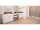 Elegant bathroom with double sinks, vanity seating, walk-in shower, and neutral tile flooring at 4374 Rhyme St, Kissimmee, FL 34746
