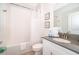 Bright bathroom featuring a shower-tub combo with white tile and gray countertops at 4374 Rhyme St, Kissimmee, FL 34746