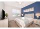 Cozy bedroom with a blue accent wall, neutral carpet, and bright natural light at 4374 Rhyme St, Kissimmee, FL 34746