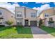 Modern two-story home featuring a paver driveway, green lawn, and nicely manicured landscaping at 4374 Rhyme St, Kissimmee, FL 34746