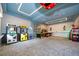 Spacious game room with classic arcade games, patterned carpet and a unique ceiling design at 4374 Rhyme St, Kissimmee, FL 34746