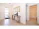 Hallway featuring tile floors, a decorative table, and a view of the front door and bathroom at 4374 Rhyme St, Kissimmee, FL 34746