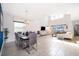 Open-concept living and dining area with sleek tile flooring, large windows, and modern decor at 4374 Rhyme St, Kissimmee, FL 34746
