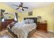 Bedroom with yellow walls, wood floors, ceiling fan, dresser and a comfortable bed at 4620 Eaglet Ln, Kissimmee, FL 34746