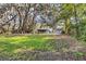 Spacious backyard featuring a charming light-blue home surrounded by lush greenery and mature trees at 530 Mckenzie Rd, Lake Helen, FL 32744