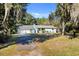 Inviting single-story home with a paved driveway, lush lawn and a small American flag at 530 Mckenzie Rd, Lake Helen, FL 32744
