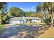 Inviting single-story home with a paved driveway, lush lawn and a small American flag at 530 Mckenzie Rd, Lake Helen, FL 32744