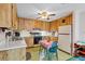 Traditional kitchen with wooden cabinets, appliances, and a breakfast table, offering a functional cooking space at 530 Mckenzie Rd, Lake Helen, FL 32744