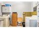 Bright laundry room with washer, dryer, storage and folding table at 530 Mckenzie Rd, Lake Helen, FL 32744