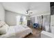 Bright bedroom featuring hardwood floors, a ceiling fan, a comfortable bed, and ample natural light at 711 Briarwood Dr, Winter Springs, FL 32708