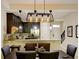 Dining area with modern pendant lighting open to kitchen and staircase at 8141 Roseville Blvd, Davenport, FL 33896