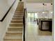 Bright interior with stairs, tile flooring, open kitchen, and sliding doors to patio at 8141 Roseville Blvd, Davenport, FL 33896