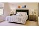 Well-lit main bedroom with a decorative headboard, bedside tables, neutral paint, and large window at 8141 Roseville Blvd, Davenport, FL 33896