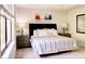 Bright main bedroom featuring a decorative headboard, bedside tables, neutral paint, and large window at 8141 Roseville Blvd, Davenport, FL 33896