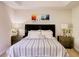Well-lit main bedroom with a decorative headboard, bedside tables, neutral paint, and large window at 8141 Roseville Blvd, Davenport, FL 33896