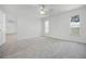 The spacious bedroom features neutral paint, plush carpeting, and a bright window at 600 Park Valley Cir, Minneola, FL 34715