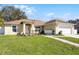 Home with a manicured lawn, and a decorative bridge and walkway at 600 Park Valley Cir, Minneola, FL 34715