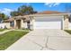 Home with a manicured lawn, decorative walkway and an attached garage at 600 Park Valley Cir, Minneola, FL 34715