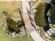 Aerial view of a well-maintained koi pond with a wooden bridge and lush greenery surrounding it at 600 Park Valley Cir, Minneola, FL 34715