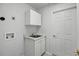 Laundry room boasts a utility sink, ample cabinet storage, and a door to the side yard at 600 Park Valley Cir, Minneola, FL 34715