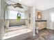 Bathroom featuring a tub with a shower, decorative dolphin fixtures, and a vanity with storage at 1008 Turtle Creek Dr, Oviedo, FL 32765