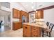 Bright kitchen with brown cabinets, granite countertops, stainless steel appliances, and a large island with bar seating at 1008 Turtle Creek Dr, Oviedo, FL 32765