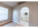 Bathroom with archway entry offers modern white vanity and a round mirror over hexagon tile floor at 10142 Richardson Ct, Orlando, FL 32825