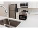 Kitchen sink with modern stainless steel appliances and white cabinets in background at 10142 Richardson Ct, Orlando, FL 32825