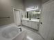 Bathroom featuring a soaking tub and vanity with white cabinets at 10446 Stone Glen Dr, Orlando, FL 32825