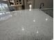 Close-up of kitchen island with white countertop and modern faucet, overlooking living area at 10446 Stone Glen Dr, Orlando, FL 32825