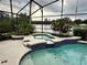Inviting pool with hot tub, complemented by lush landscaping and a serene water view at 10446 Stone Glen Dr, Orlando, FL 32825