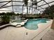 Sparkling pool and hot tub with screened enclosure overlooking a serene lake at 10446 Stone Glen Dr, Orlando, FL 32825