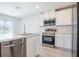 Bright kitchen with stainless steel appliances, white cabinets, and an island with a sink and dishwasher at 113 Carlisle Ct, Kissimmee, FL 34758