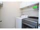 Functional laundry room with modern washer and dryer units and overhead storage at 1139 Sand Creek Loop, Ocoee, FL 34761